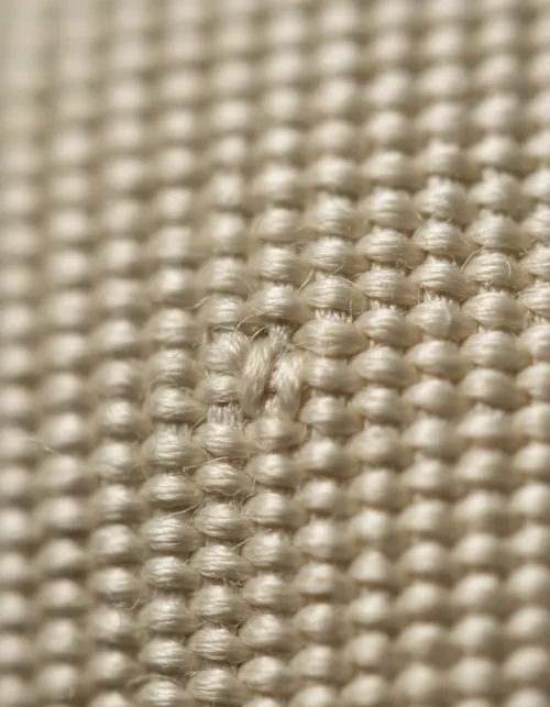 Close-up embroidery thread on textured dark fabric